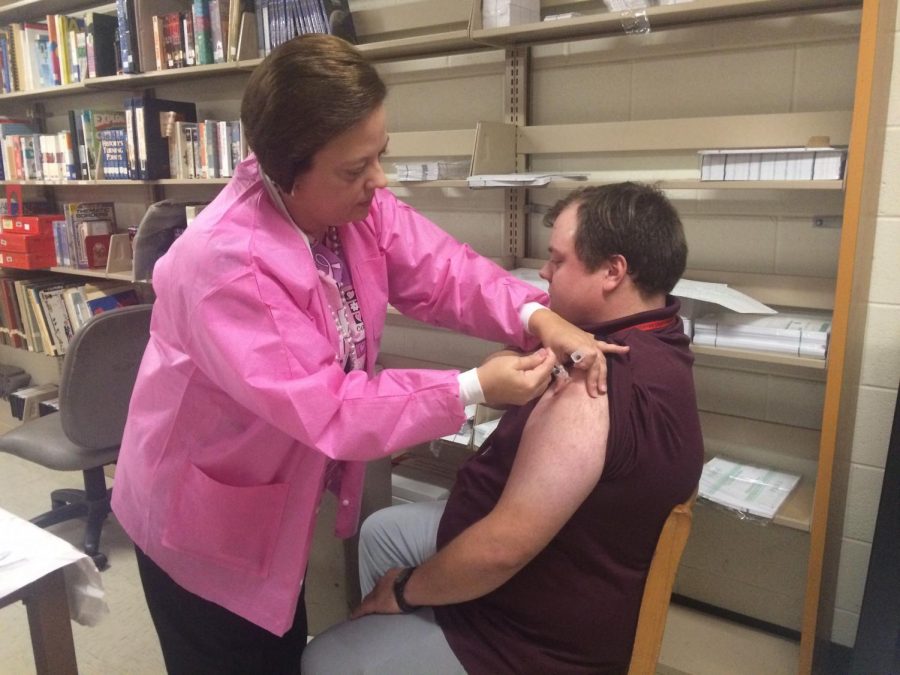 Mr. King receives a dose of the flu shot.