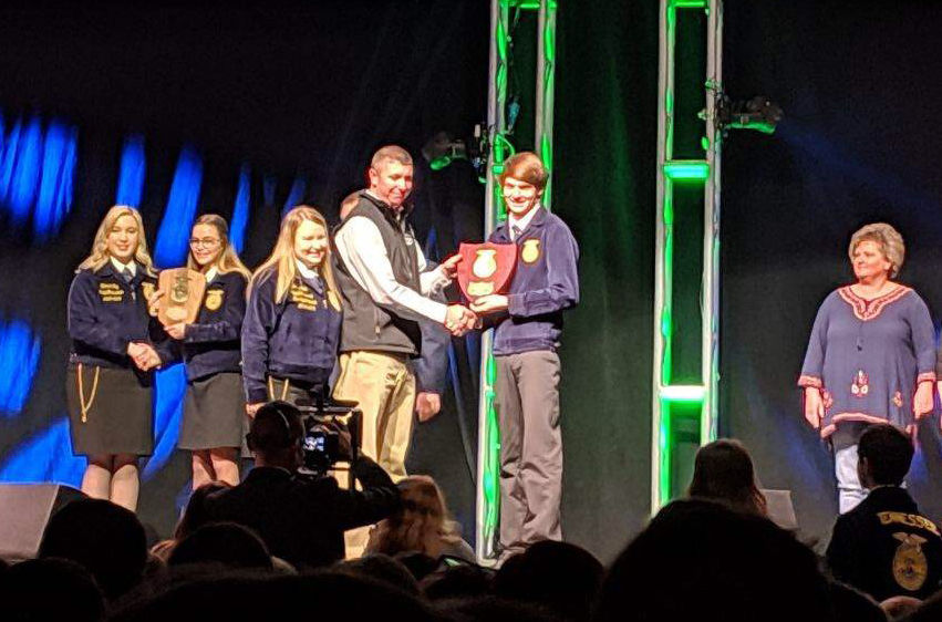 Josh Barnard receives his award for winning the extemporaneous speech contest at the FFA convention.