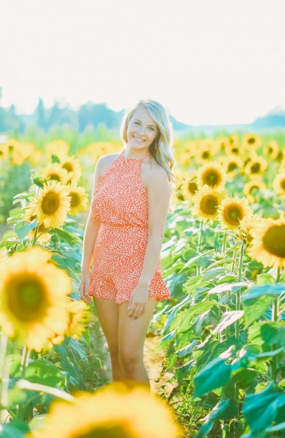 Kylie standing in a field of flowers.