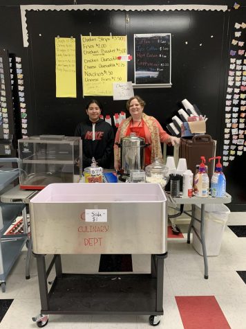 Mrs. Louden and a culinary student standing at their FACs fundraising booth. 