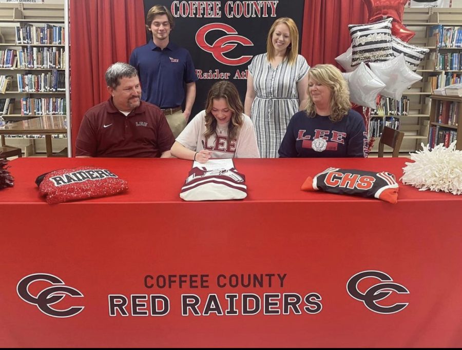 Makenna Orrick signs surrounded by her family and dance coach.