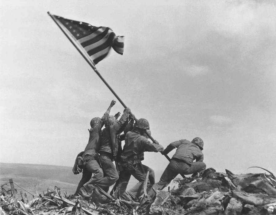 In a passionate moment captured by American photographer Joe Rosenthal, American soldiers at Iwo Jima raise an American flag up to the sky together.
