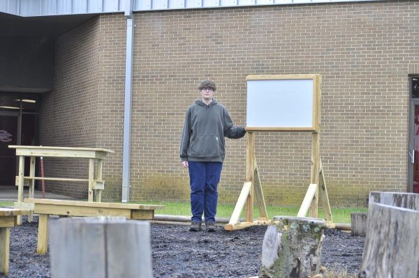 Senior Aidan Hetrick stands alongside the finished outdoor classroom post-renovation.